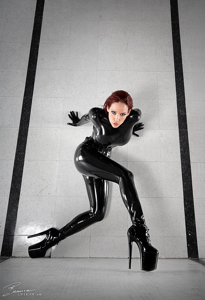 bianca_beauchamp breasts catsuit female gloves high_heels large_breasts latex long_hair red_hair shoes solo watermark