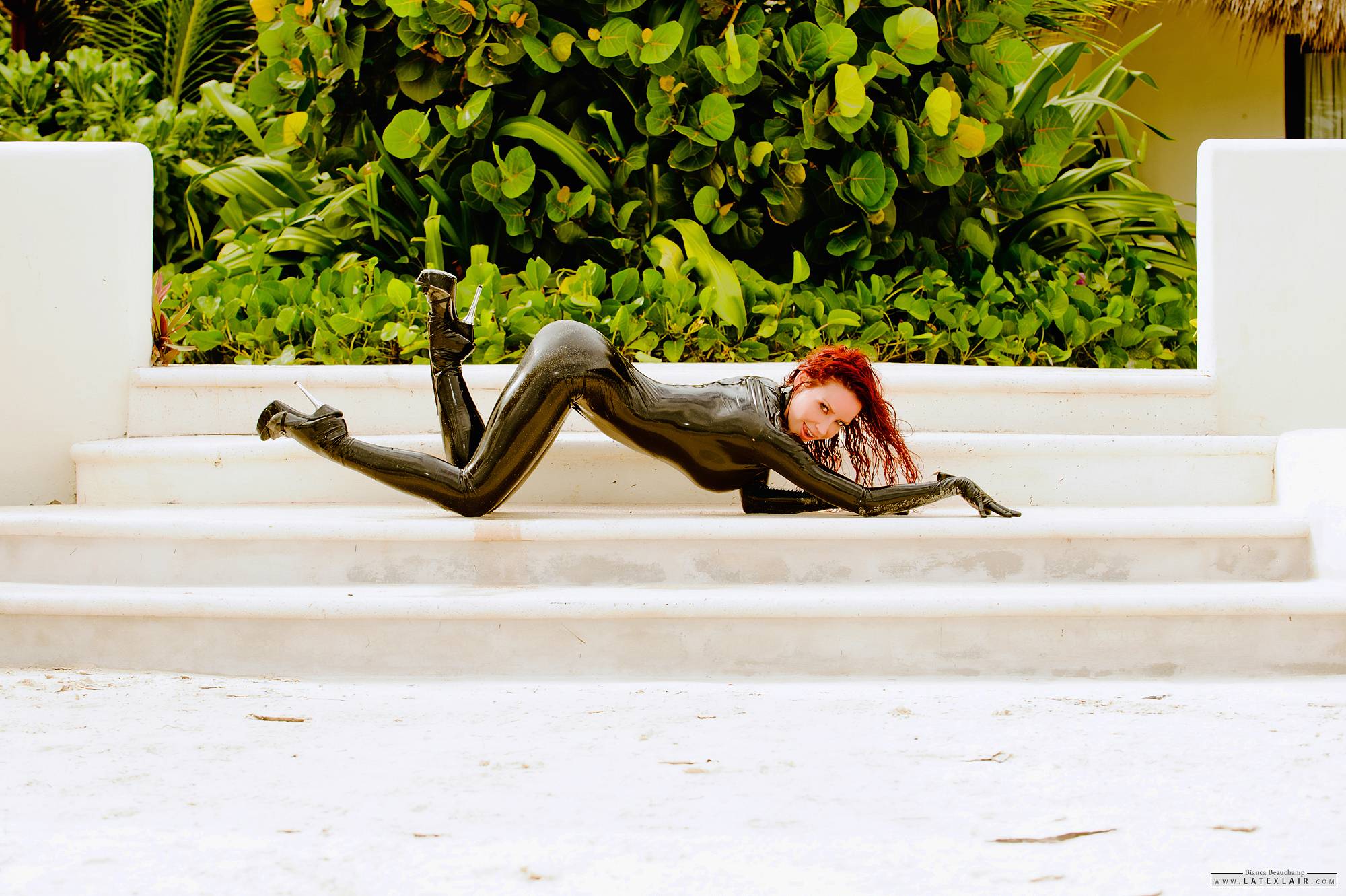 ass bianca_beauchamp breasts catsuit female high_heels large_breasts latex long_hair looking_back outside red_hair shoes shower solo water watermark wet
