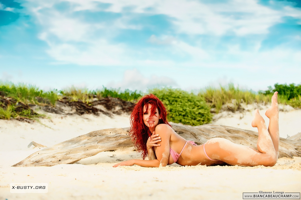 beach bianca_beauchamp bikini breasts cleavage female large_breasts long_hair midriff navel navel_piercing outside piercing red_hair sand solo