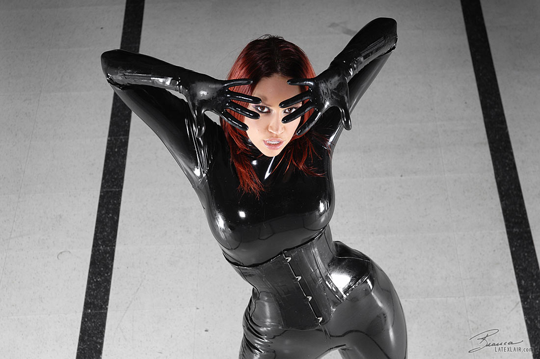 bianca_beauchamp breasts catsuit female gloves high_heels large_breasts latex long_hair red_hair shoes solo watermark