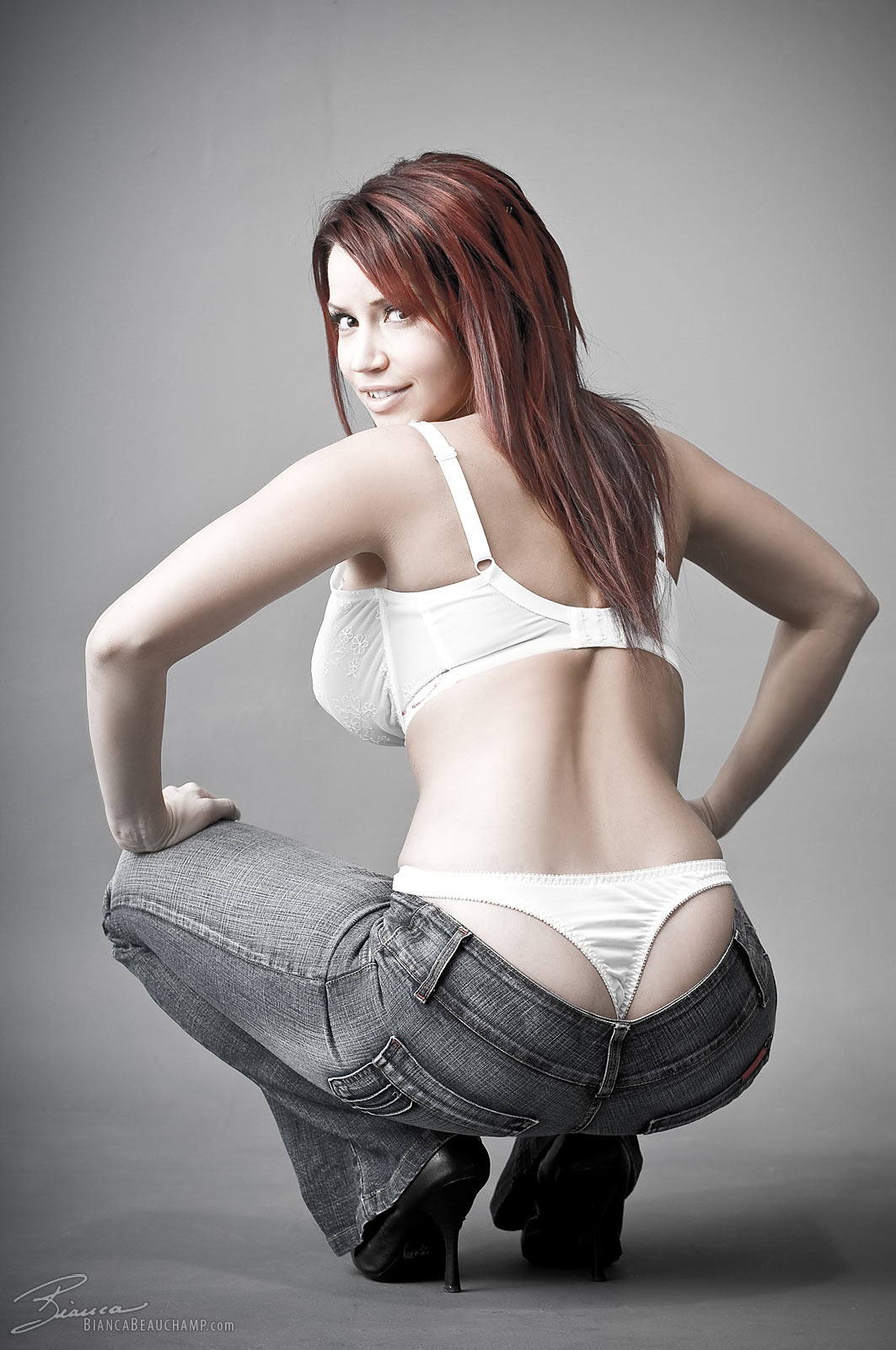 ass bianca_beauchamp breasts female jeans large_breasts long_hair looking_back red_hair simple_background solo watermark
