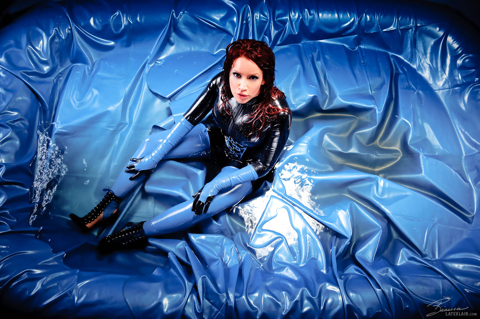 bianca_beauchamp breasts catsuit corset female gloves large_breasts latex long_hair makeup red_hair simple_background solo water watermark wet