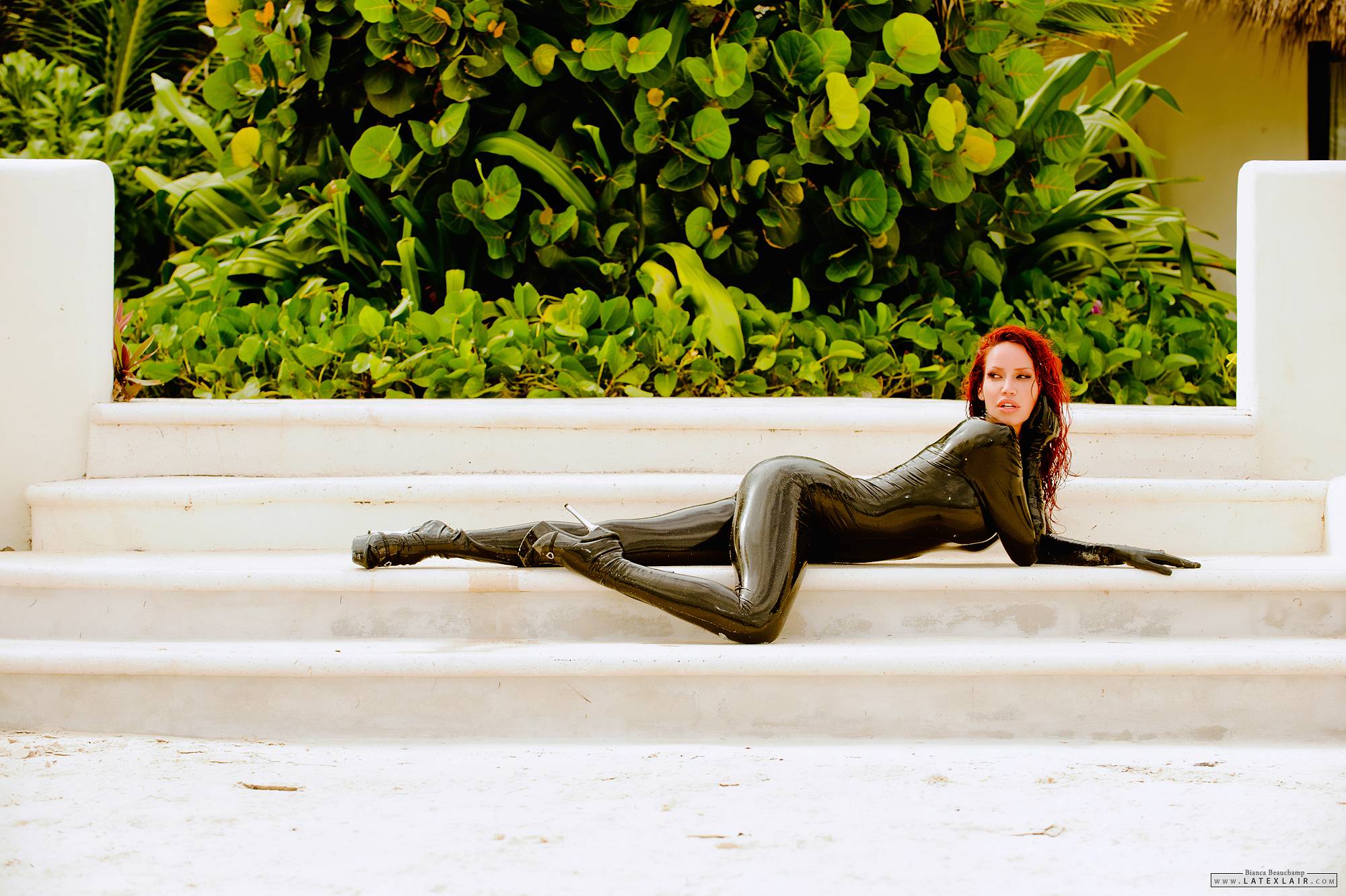 ass bianca_beauchamp breasts catsuit female high_heels large_breasts latex long_hair looking_back outside red_hair shoes shower solo water watermark wet