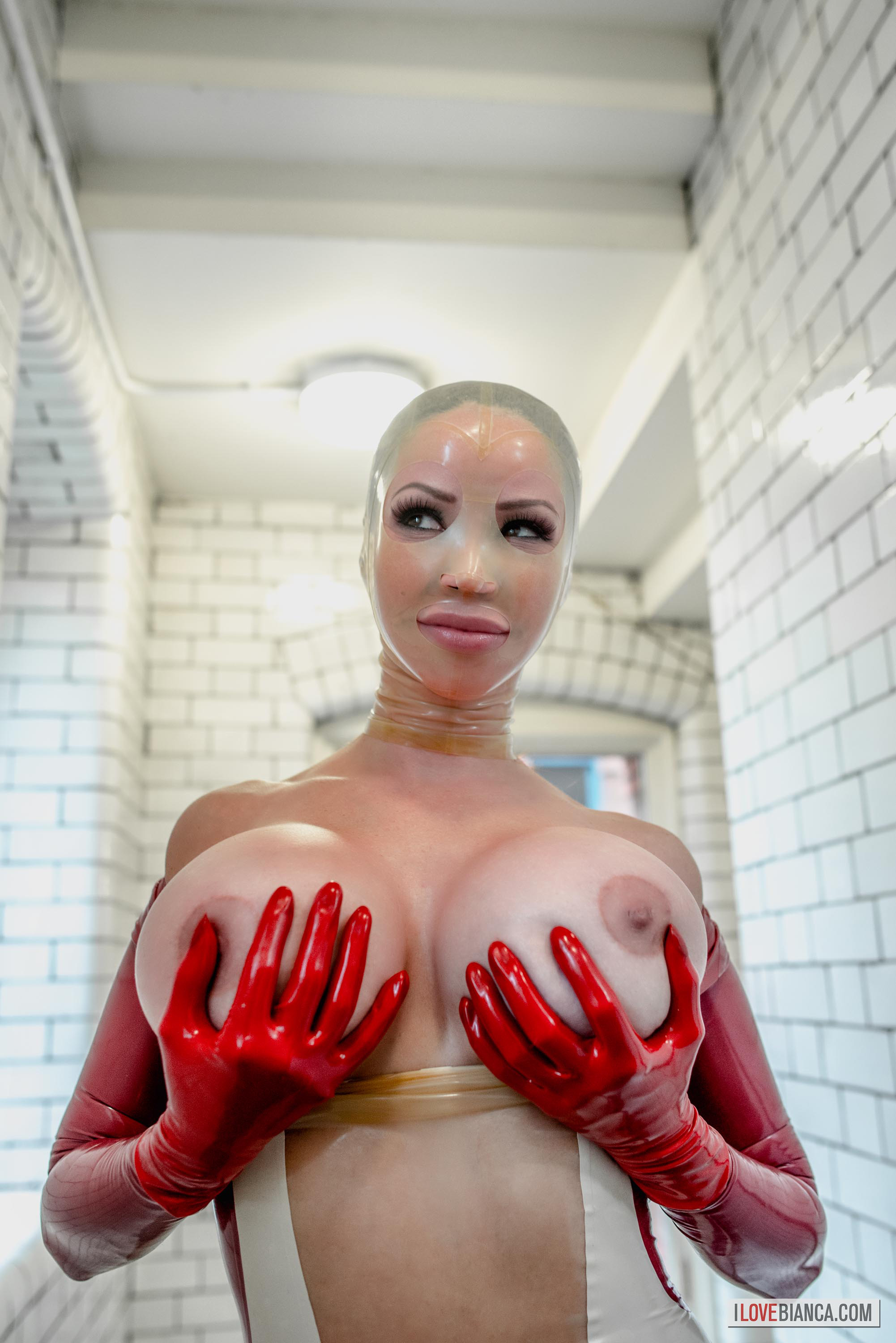 bianca_beauchamp breasts catsuit female gloves high_heels large_breasts latex long_hair red_hair shoes solo watermark