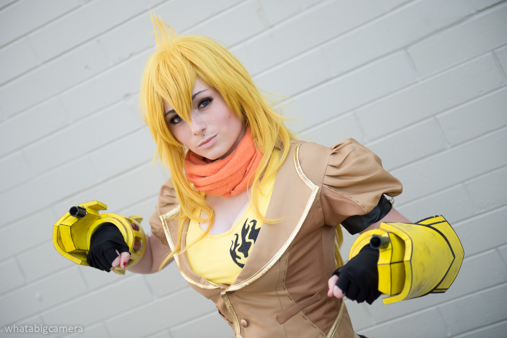 1girl bare_shoulders blonde_hair breasts chaps cosplay female kayla_erin large_breasts long_hair midriff outside rwby solo yang_xiao_long