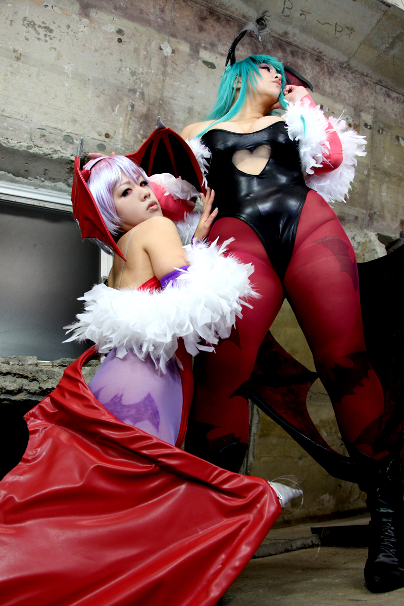 2girls aqua_hair ass bare_shoulders breasts chouzuki_maryou cleavage cosplay darkstalkers demon_wings female female_only high_heel_boots huge_breasts leotard lilith_aensland long_hair looking_at_viewer looking_away morrigan_aensland non-nude pantyhose partially_clothed plump purple_hair solo squatting succubus suzuka_itsuki thong_leotard watermark wings