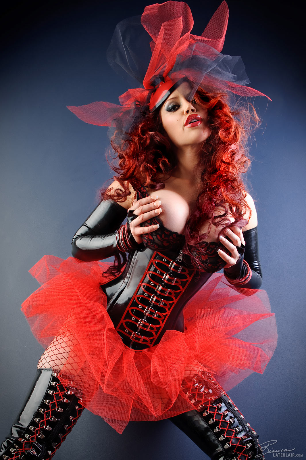 bianca_beauchamp boots breasts cleavage corset erect_nipples female fishnets large_breasts latex lipstick long_hair nipples red_hair simple_background skirt solo topless watermark