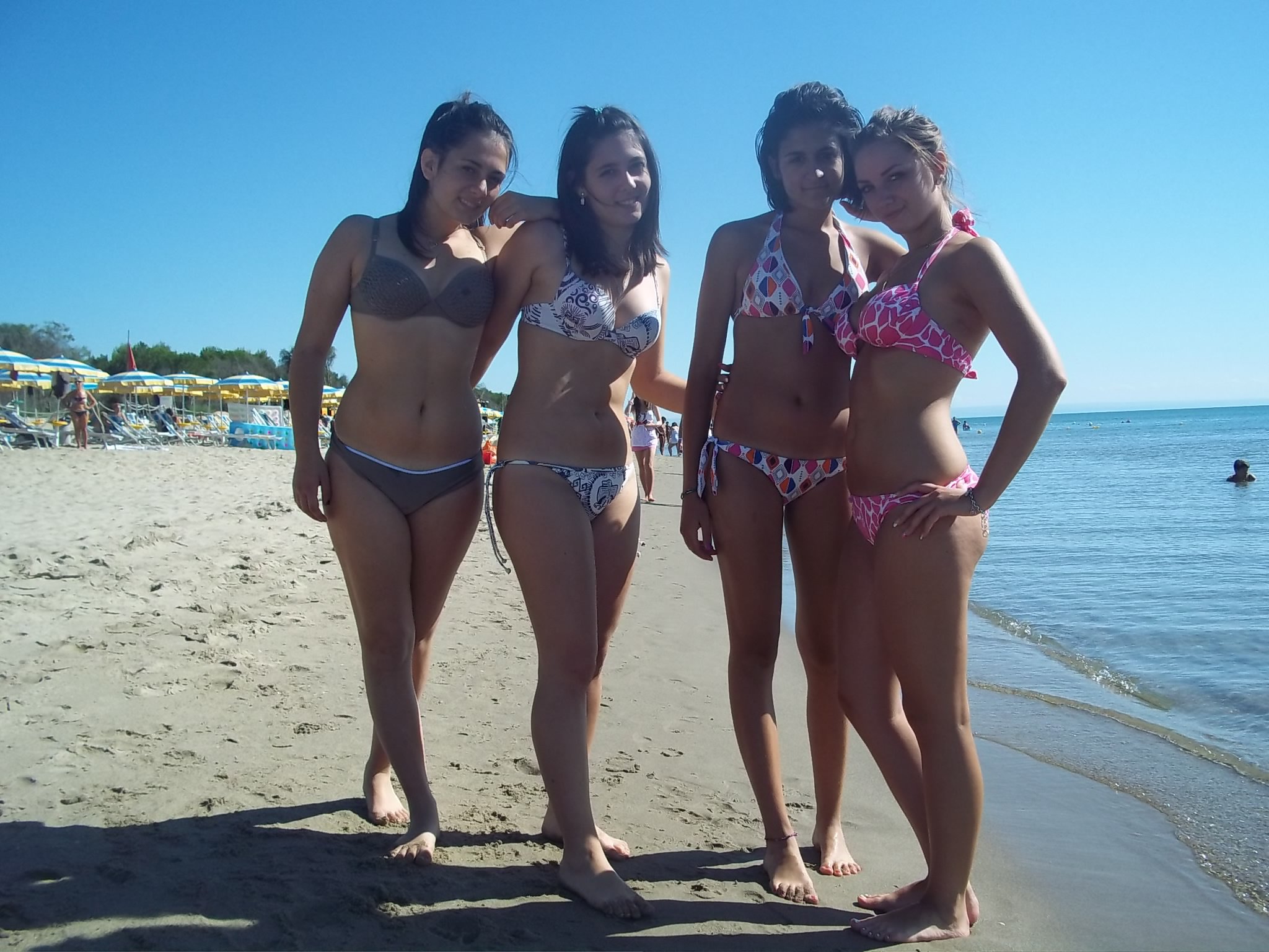 4girls anklet barefoot beach bikini black_hair brown_hair feet female female_only legs looking_at viewer multiple_girls navel outside side-tie_bikini smile swimsuit toes water