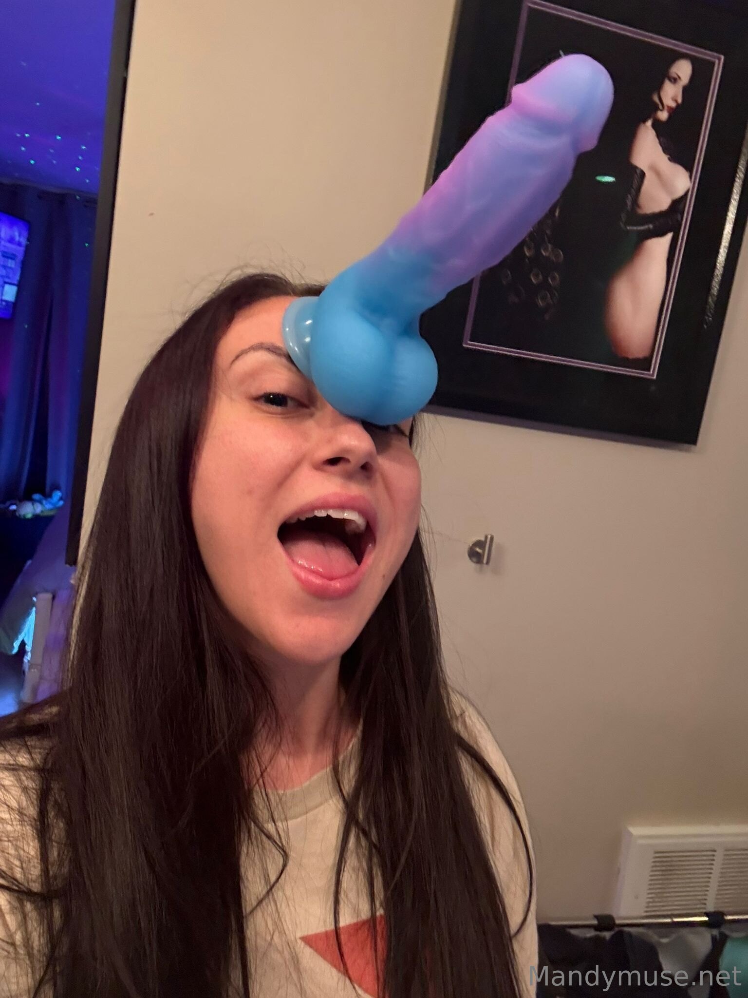 1girl bedroom big_dildo brown_hair brunette dildo dildo_on head female female_focus female_only female_solo lipstick long_hair looking_at viewer makeup mandy_muse onlyfans open_mouth pornstar selfie sex_toy silly solo sweater text watermark