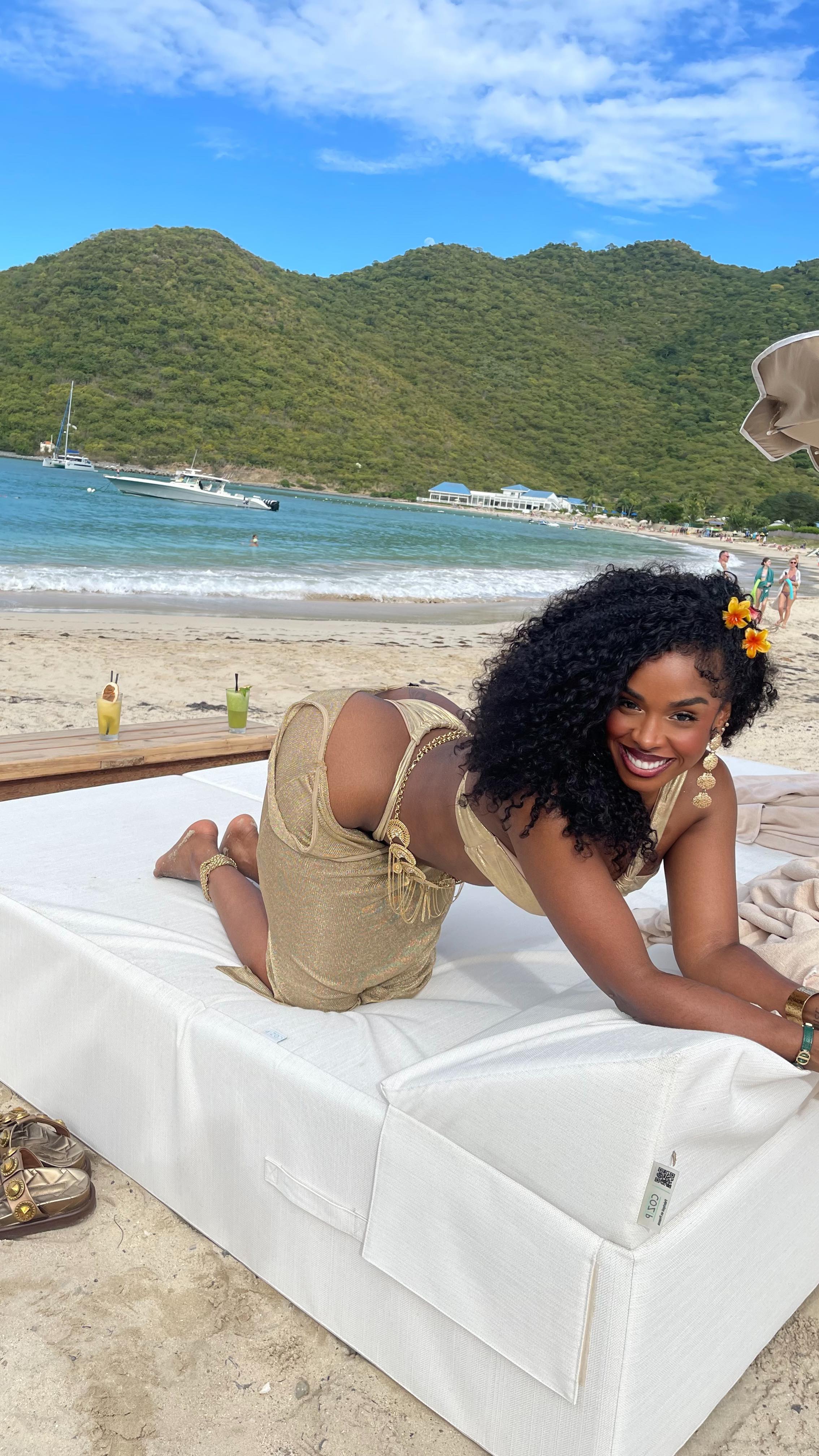 1girl all_fours ass beach bikini black_hair breasts clothed clothed_female curly_hair female female_focus female_only female_solo long_hair looking_at viewer partially_clothed smile solo solo_female solo_focus