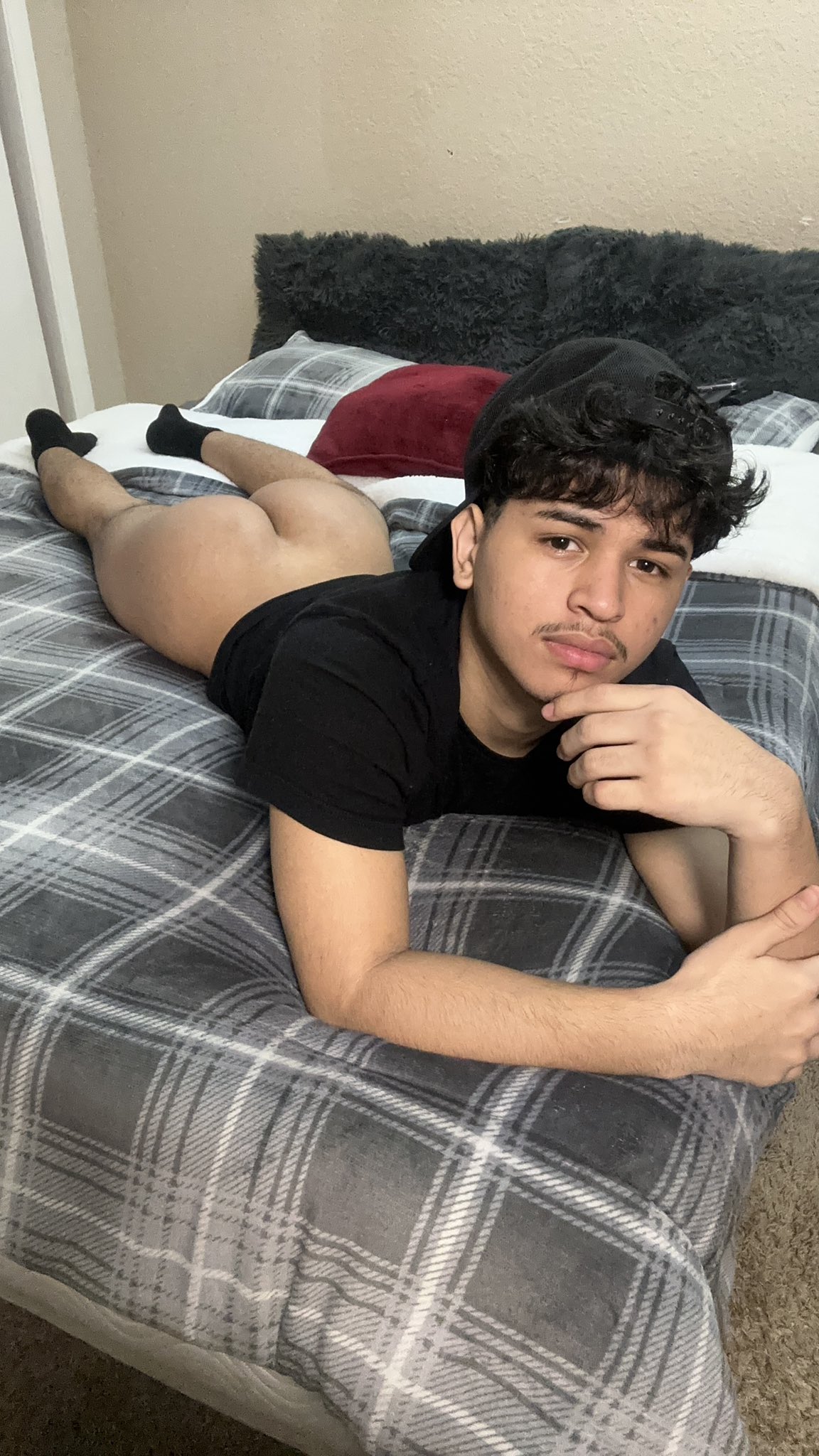 1boy ass backwards_cap bed black_hair bottomless cap gay hat honduran latino lying lying_on stomach male male_only on_bed shirt socks solo solo_male sourced twitter xxcciiaa