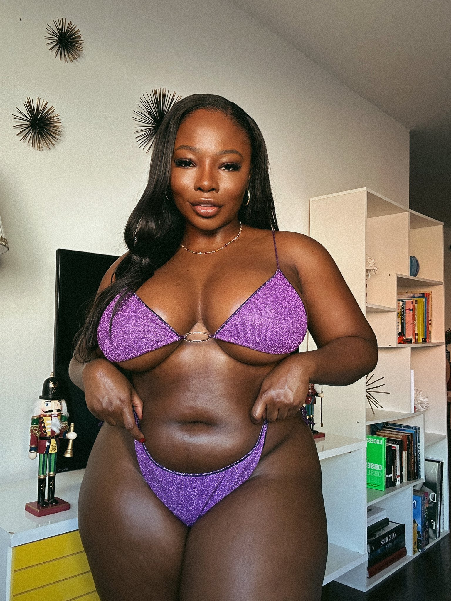 big_breasts bikini black_female black_hair curvy earrings ebony holding_panties indoors isabelle_miller lip_gloss lips looking_at the viewer looking_at viewer necklace purple_panties sole_female thick