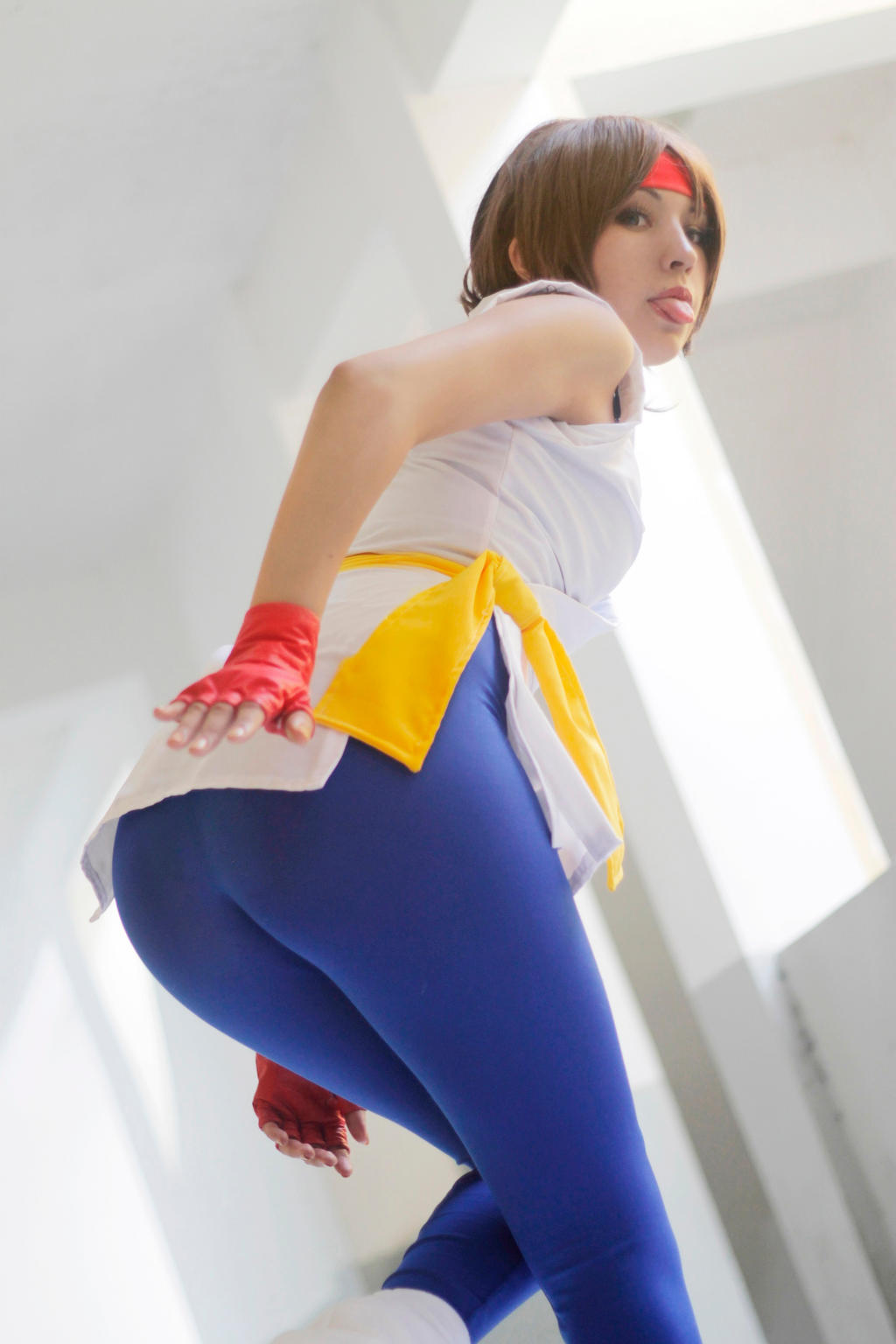 1girl art_of fighting ass brown_hair cosplay cosplay_photo dougi female female_focus female_only fingerless_gloves headband highres indoors katta_ramos king_of fighters photo_(medium) ryuuko_no ken snk solo spandex tongue tongue_out yuri_sakazaki