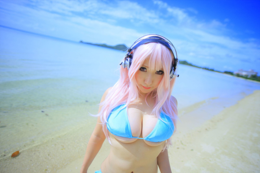 1girl asian beach bikini breasts cleavage cosplay female headphones japanese large_breasts lipstick long_hair navel outside pink_hair shooting_star solo super_sonico water