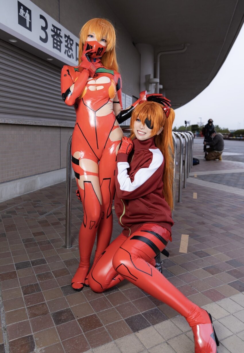 2girls asian asuka_langley_sohryu bodysuit breasts cleavage cosplay eyepatch facemask glico_happy jacket japanese latex multiple_girls neon_genesis_evangelion orange_hair outside plugsuit torn_clothes