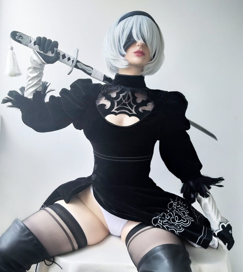 1girl 2b anime blindfold cosplay crotch epicinternetgf form_fitting gloves groin highres hip_cleavage leotard lips nier:_automata pale pale-skinned_female pale_skin photo revealing_clothes simple_background sitting solo solo_female solo_focus sourced spread_legs studio_background thighs thong twitter white_hair wig yorha_2b