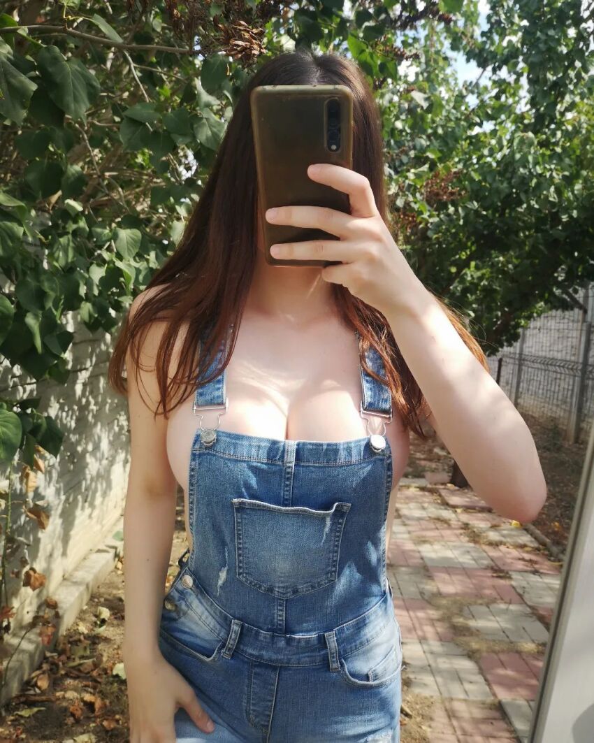 brunette cleavage covering_face faceless_female female large_breasts naked_overalls outdoors outside overalls pale pale-skinned_female pale_skin phone photo selfie