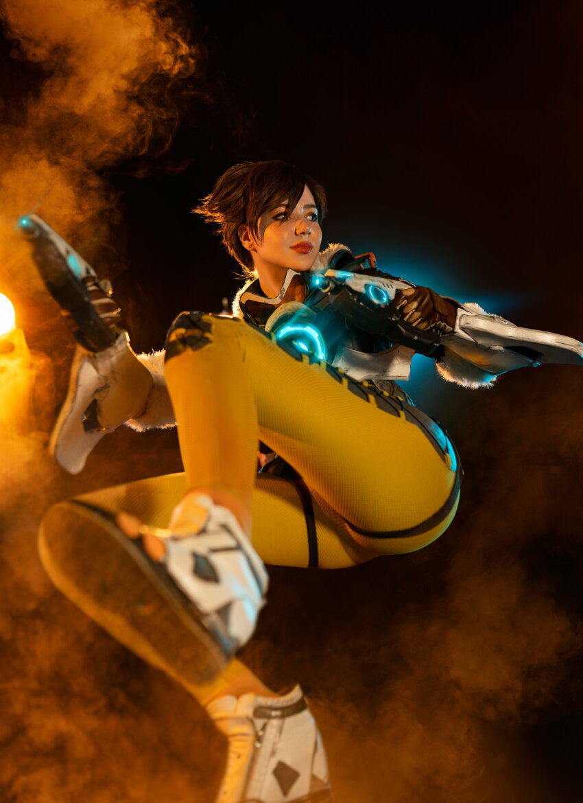 1girl alina_becker blizzard_entertainment brunette clothed clothed_female cosplay dark_hair dark_haired_female female_focus female_only form_fitting highres leggings non_nude overwatch photo sexually_suggestive sfw skin_tight solo solo_female solo_focus suggestive tight_clothes tight_pants tracer_(overwatch)