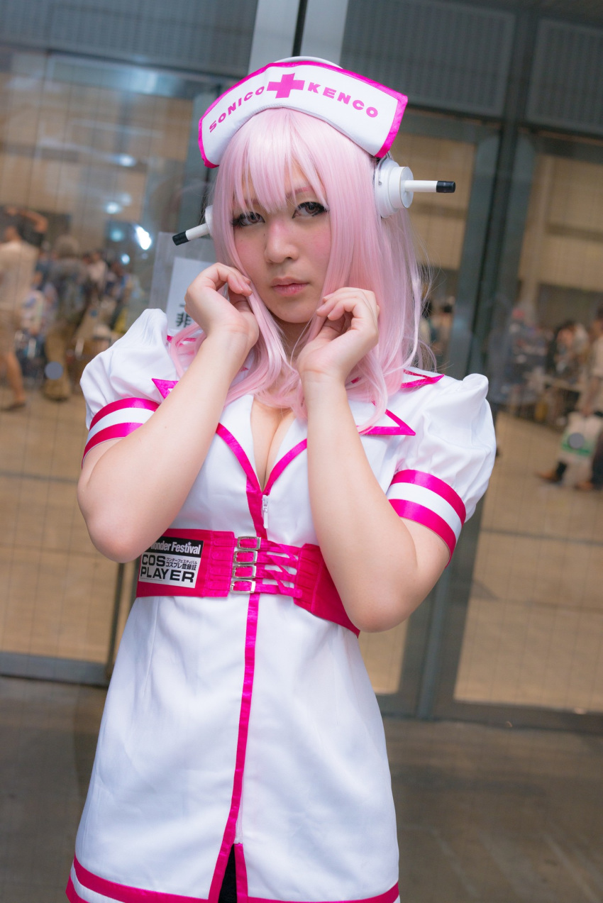 1girl asian breasts cleavage cosplay dress female headphones japanese long_hair nurse pink_hair solo super_sonico