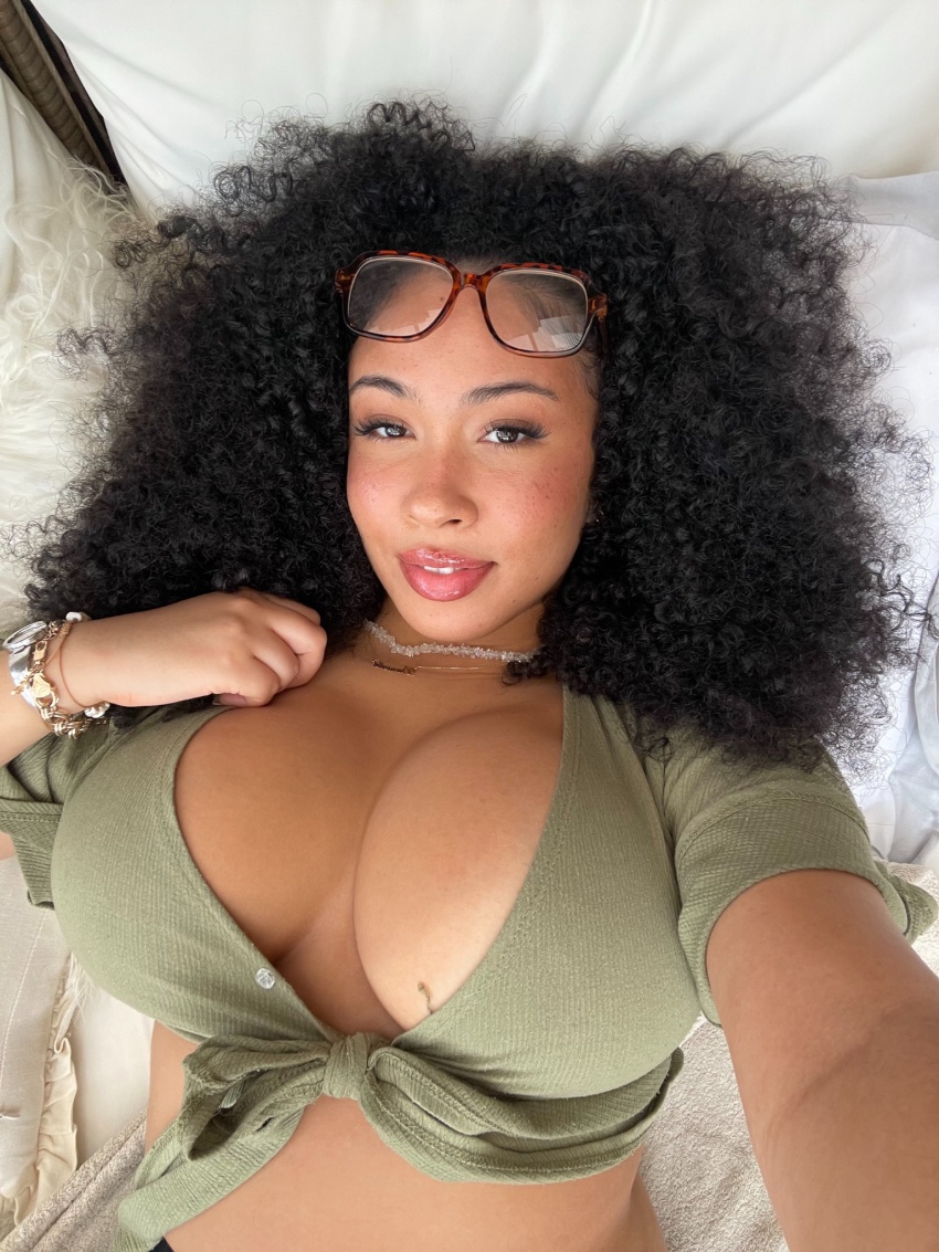 1girl bed bedroom black black_female black_hair breasts clothed clothed_female curly_hair danielle_ramona dark-skinned_female dark_skin female female_focus female_only female_solo glasses lying medium_breasts on_bed solo solo_female solo_focus