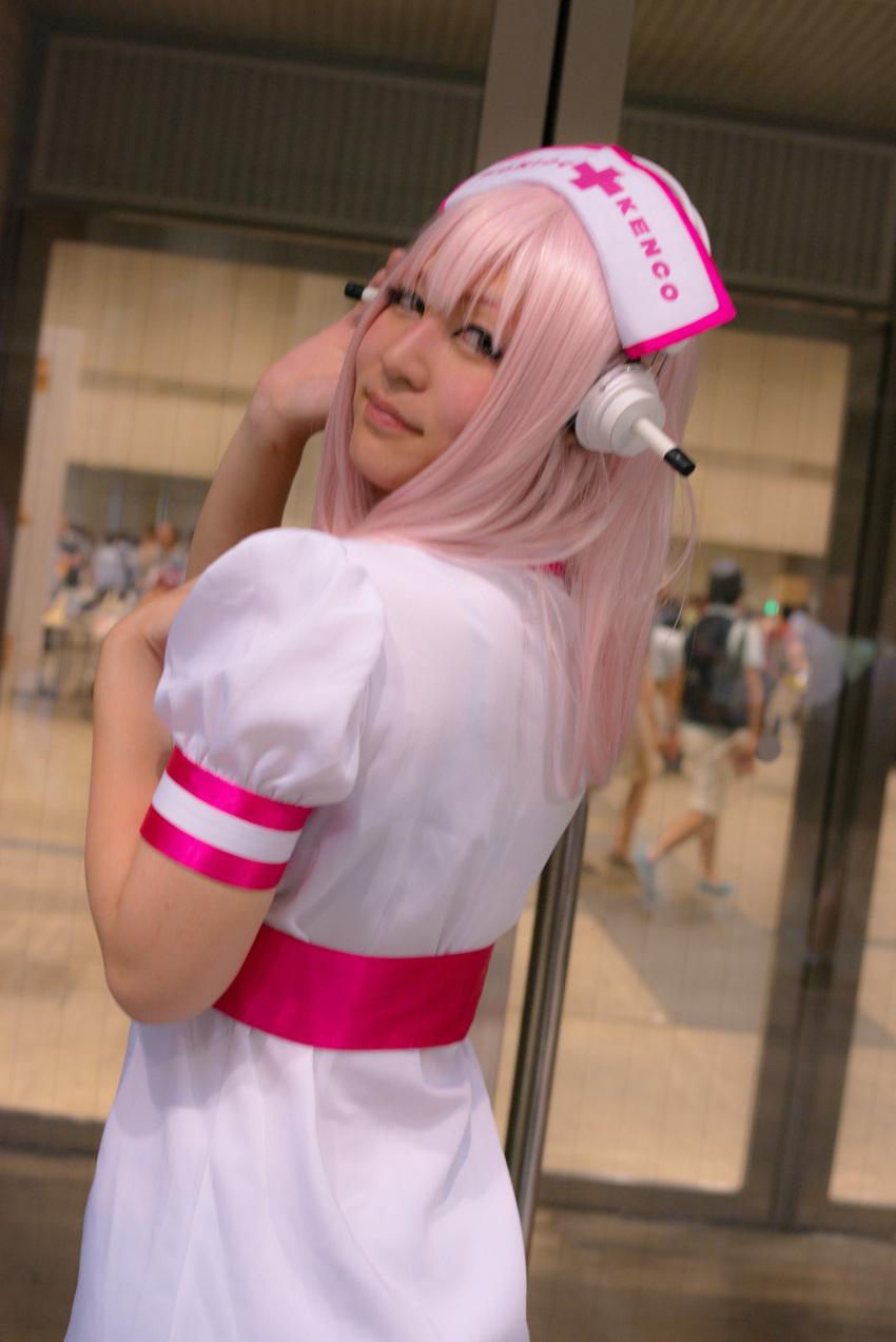 1girl asian breasts cosplay dress female headphones japanese long_hair nurse pink_hair solo super_sonico