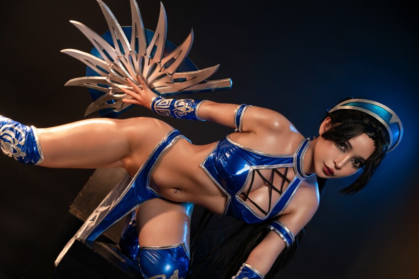 1girl asian asian_female bare_shoulders belly belly_button black_hair cleavage cosplay crotch dark_hair dark_haired_female groin highres indoors kitana legs looking_at_the_viewer looking_at_viewer mortal_kombat navel pelvic_curtain photo photoshoot revealing_clothes shiny shiny_skin simple_background solo solo_female solo_focus thighs umeko_j