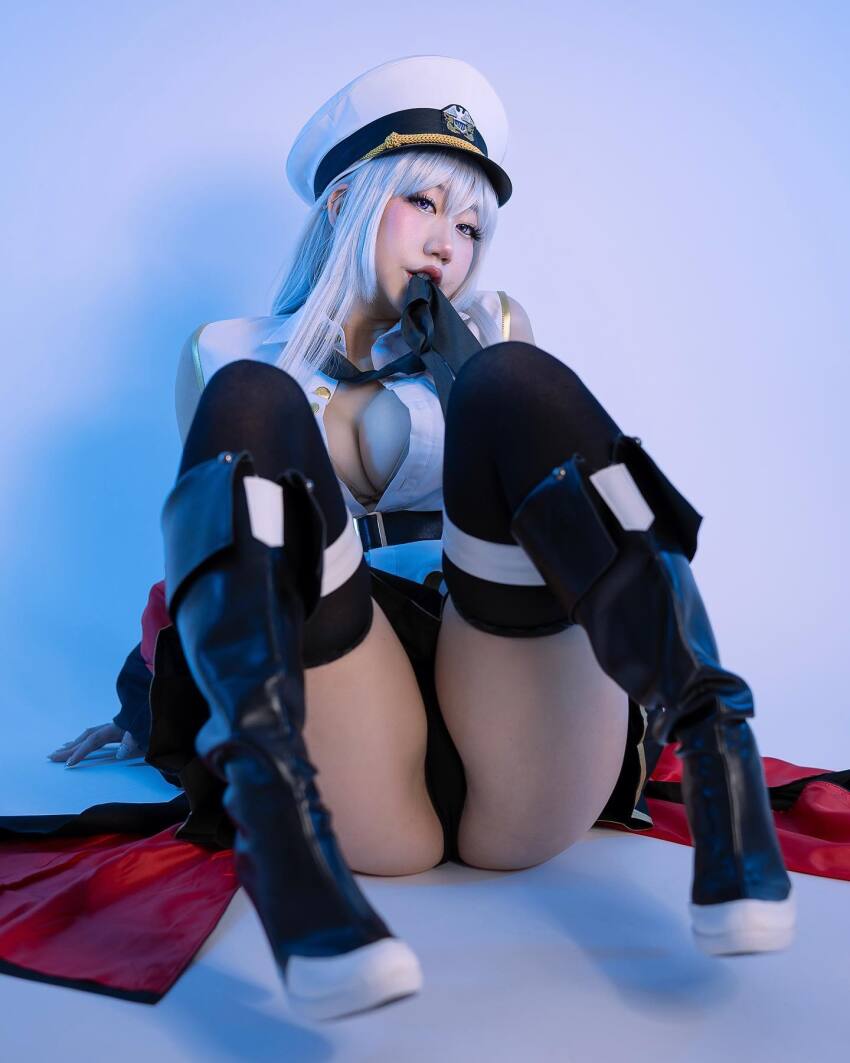 1girl asian ass azur_lane cape cleavage cosplay danisaurz enterprise_(azur_lane) high_heel_boots high_heels medium_breasts silver_hair solo spread_legs thighs