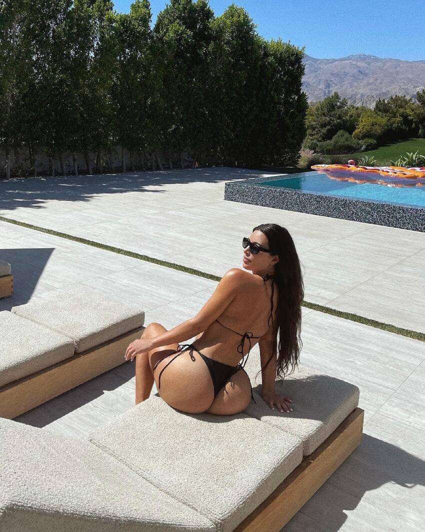 1girl black_hair breasts celebrity female female_focus female_only kim_kardashian long_hair medium_breasts pool sitting solo solo_female solo_focus sunglasses water wet wet_hair