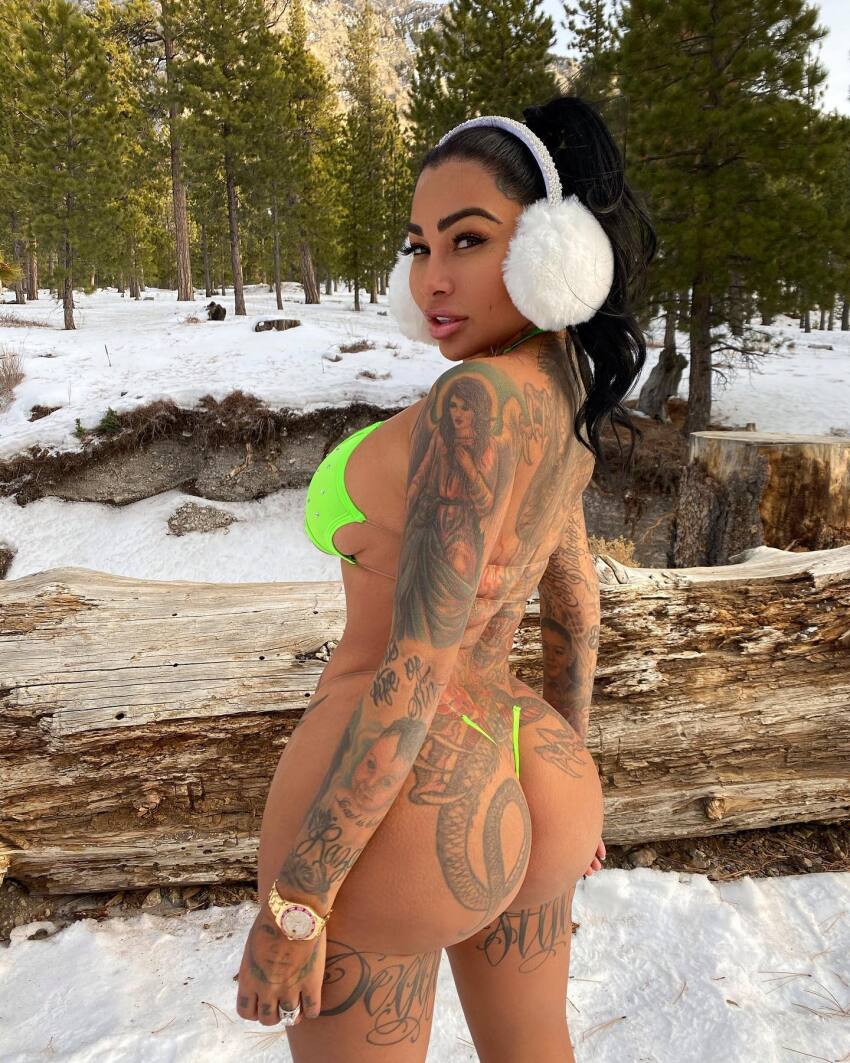 1girl ass beach bikini breasts brittanya_razavi clothed clothed_female curly_hair female female_focus female_only female_solo huge_ass huge_breasts looking_at_viewer looking_back smile snow solo solo_female solo_focus tattoo tattoo_on_arm tattoo_on_ass tattoo_on_leg tattoos