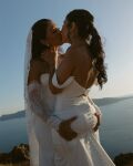 2girls ass_grab black_hair clothed clothed_female couple dress eyes_closed female female_focus female_only grabbing_ass kissing lesbian long_hair wedding_dress