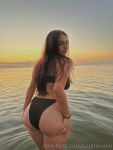 1girl ass beach bikini breasts brown_hair clothed clothed_female female female_focus female_only female_solo looking_back medium_breasts onlyfans solo solo_female solo_focus sophie_rain water watermark