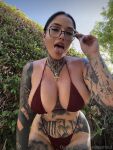 1girl andeemind bent_over big_breasts black_hair bra breasts female female_focus female_only female_solo glasses lipstick looking_at viewer makeup necklace onlyfans open_mouth outside public solo standing tattoo text thong tongue tongue_out watermark