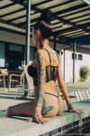 1girl ass bhad_bhabie bikini clothed clothed_female female female_focus female_only female_solo onlyfans partially_clothed pool sitting solo solo_female solo_focus tattoo tattooed_girl watermark